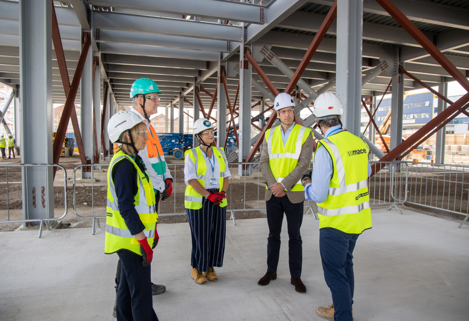The Prince of Wales talks with charity representatives at a construction site