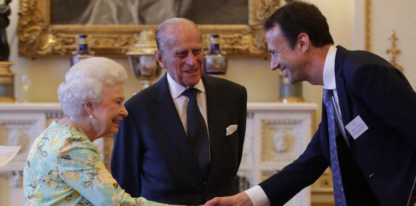 The Duke of Edinburgh looks on as The Queen meets a Queen's Awards for Enterprise winner