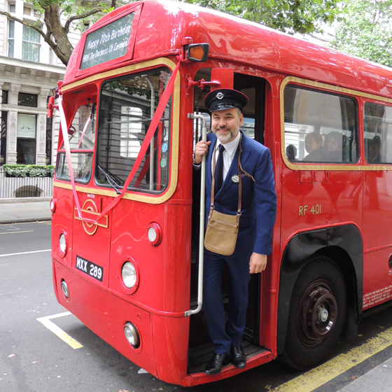 David Walliams conducts the bus that bought the school children to Clarence House