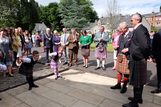 The Duke of Rothesay watches a performance by schoolchildren before visiting Bute Fabrics