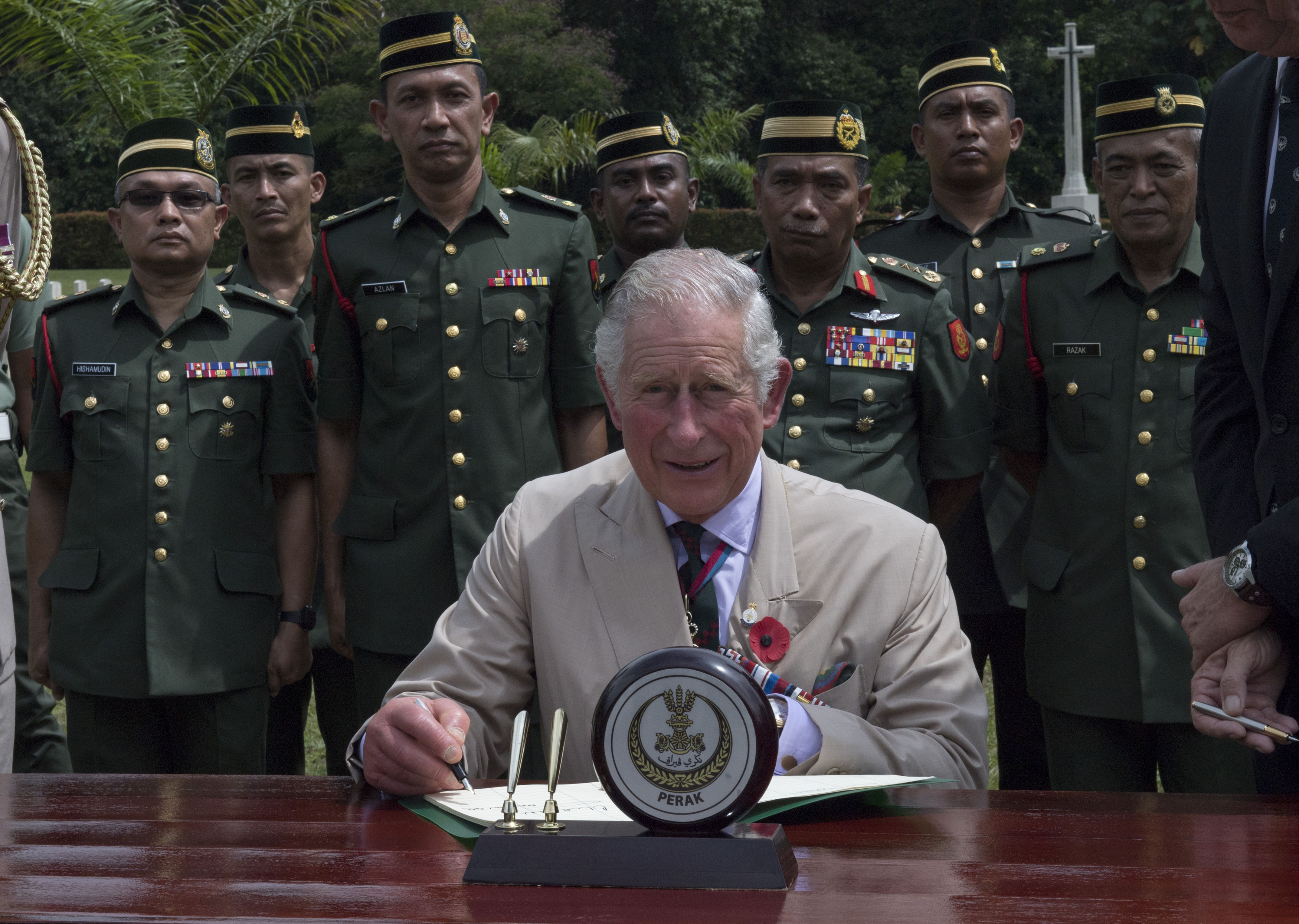The Prince of Wales signs the visitors book during a visit to the Commonwealth War Graves