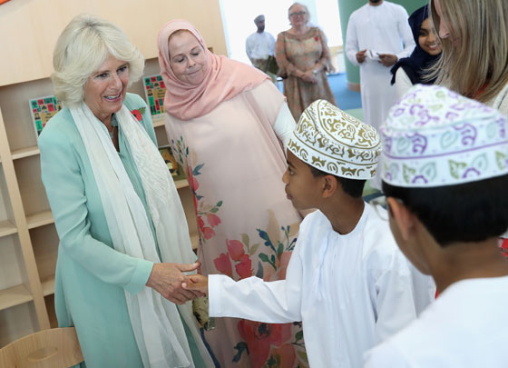 The Duchess of Cornwall meets a young boy as she visits Oman's first children's public library in Muscat