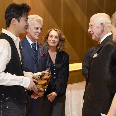 violinist Simon Zhu holding 'Il Cannone' speaking to His Majesty