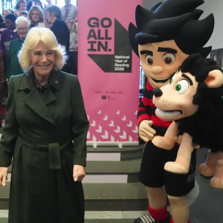 The Queen smiles alongside Beano's Dennis and Gnasher