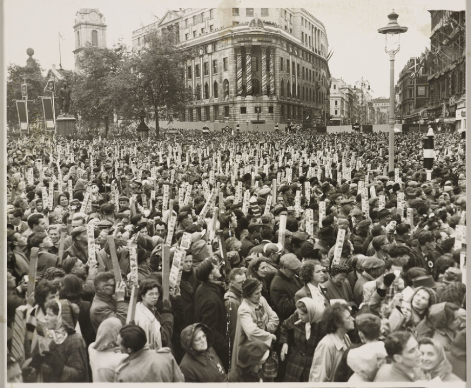 Photograph of the vast crowds standing at Trafalgar Square, using mirrors to watch the procession for the Coronation of Her Majesty Queen Elizabeth.