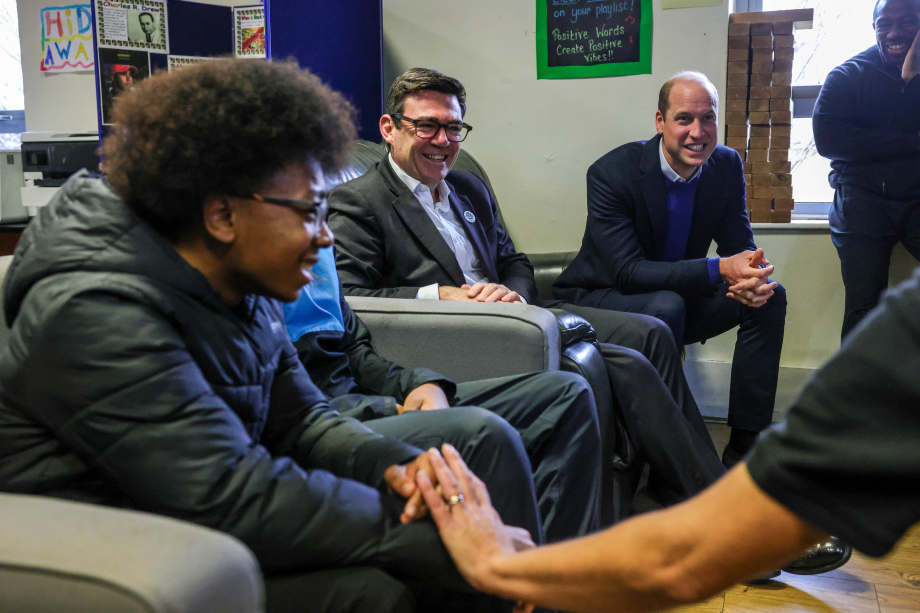 The Prince of Wales and Mayor of Greater Manchester Andy Burnham sit and talk to members of the Moss Side community