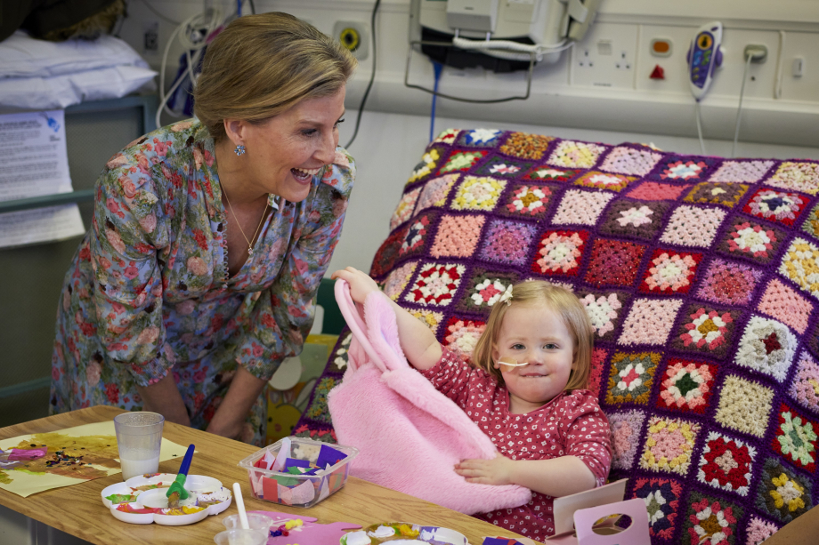 The Duchess of Edinburgh interacting with a small child on the hospital ward. 