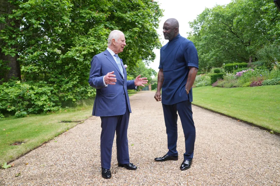 (L-R): His Majesty The King talking to Idris Elba. They are stood in a garden