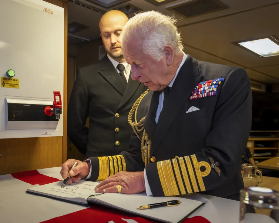 The King signs the visitor book at HM Naval Base Clyde
