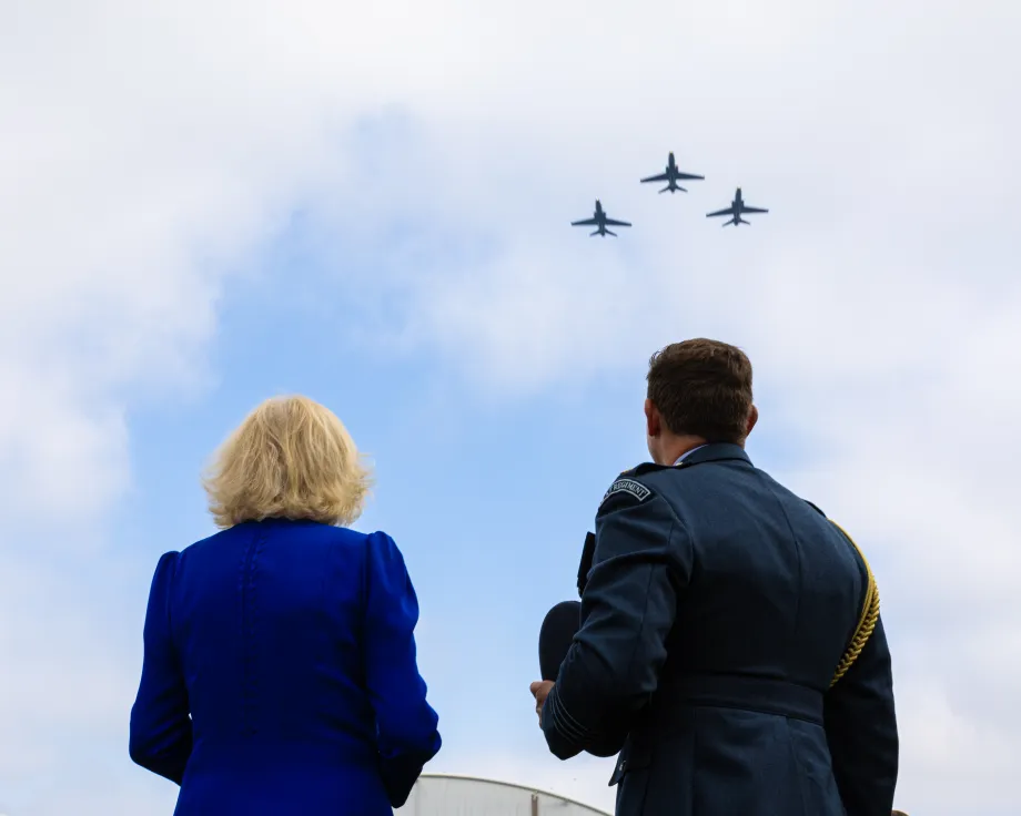 The Queen and Station Commander, Group Captain Paul Hamilton view three Hawk jets fly over RAF Leeming