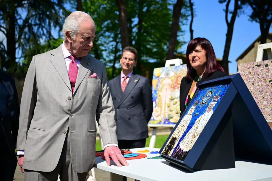 The King inserting the last tile into a mosaic