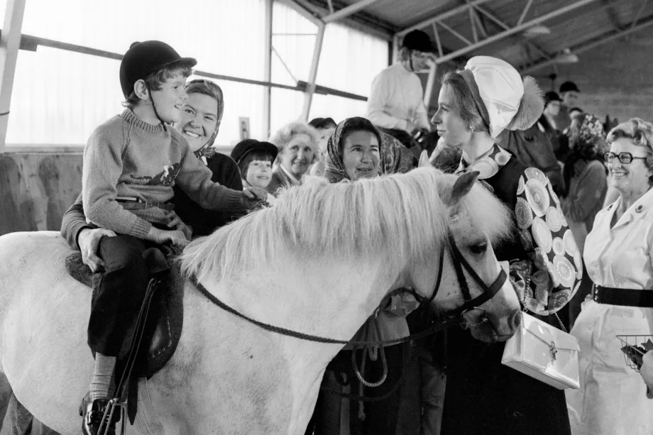 The Princess Royal chats with a young rider during her visit to Riding for the Disabled in 1973