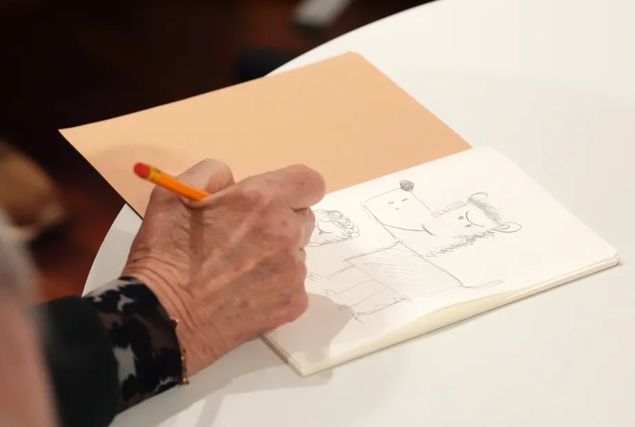 The Queen draws Gnasher during a Beano drawing workshop