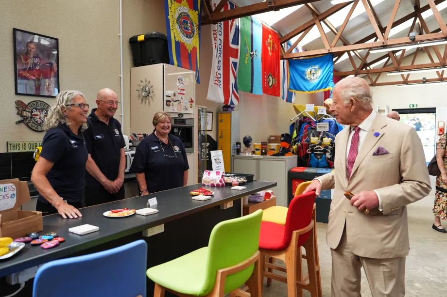 The King speaks to volunteers during a visit to the charity Heroes On The Water