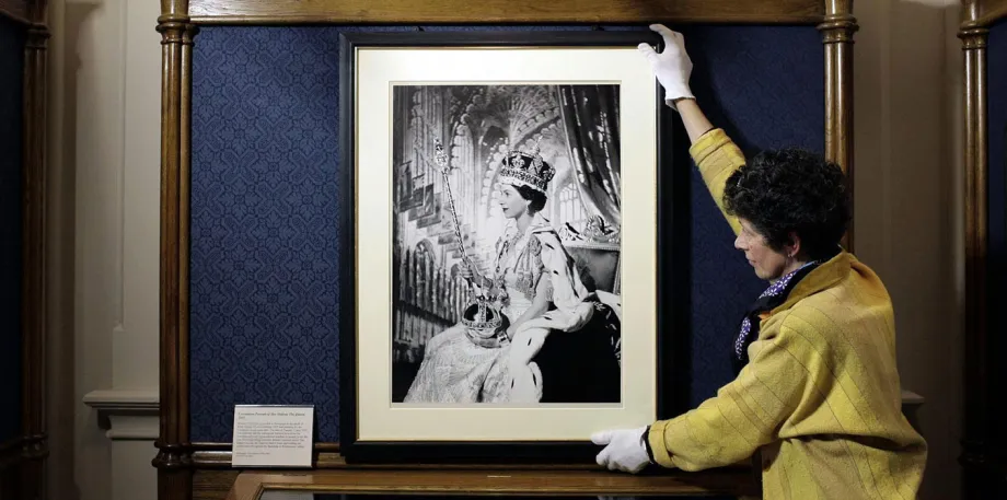 Britian's Queen Eizabeth II by Cecil Beaton from 1953, is prepared by Exhibition Co-ordinator Theresa-Mary Morton