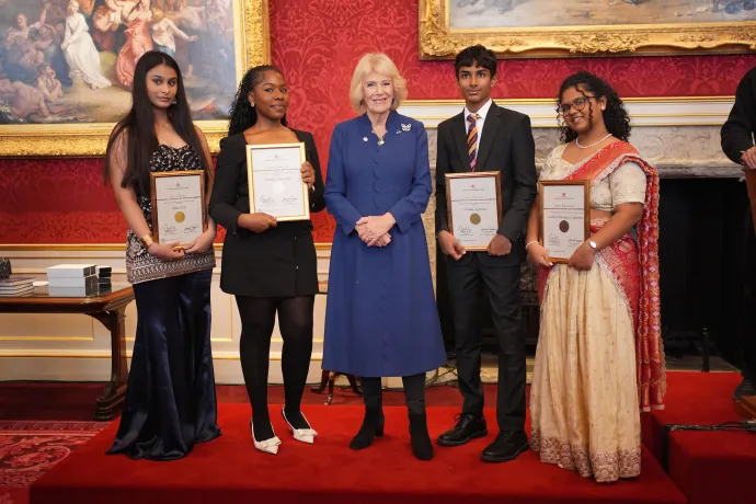 The Queen smiles alongside winners and runners-up of The Queen's Commonwealth Essay Competition