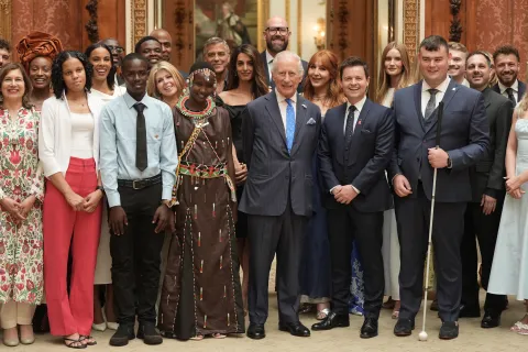The King smiles alongside King's Trust ambassadors and Awards winners