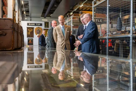 The Duke of Edinburgh looks at artefacts in a museum
