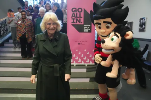 The Queen smiles alongside Beano's Dennis and Gnasher